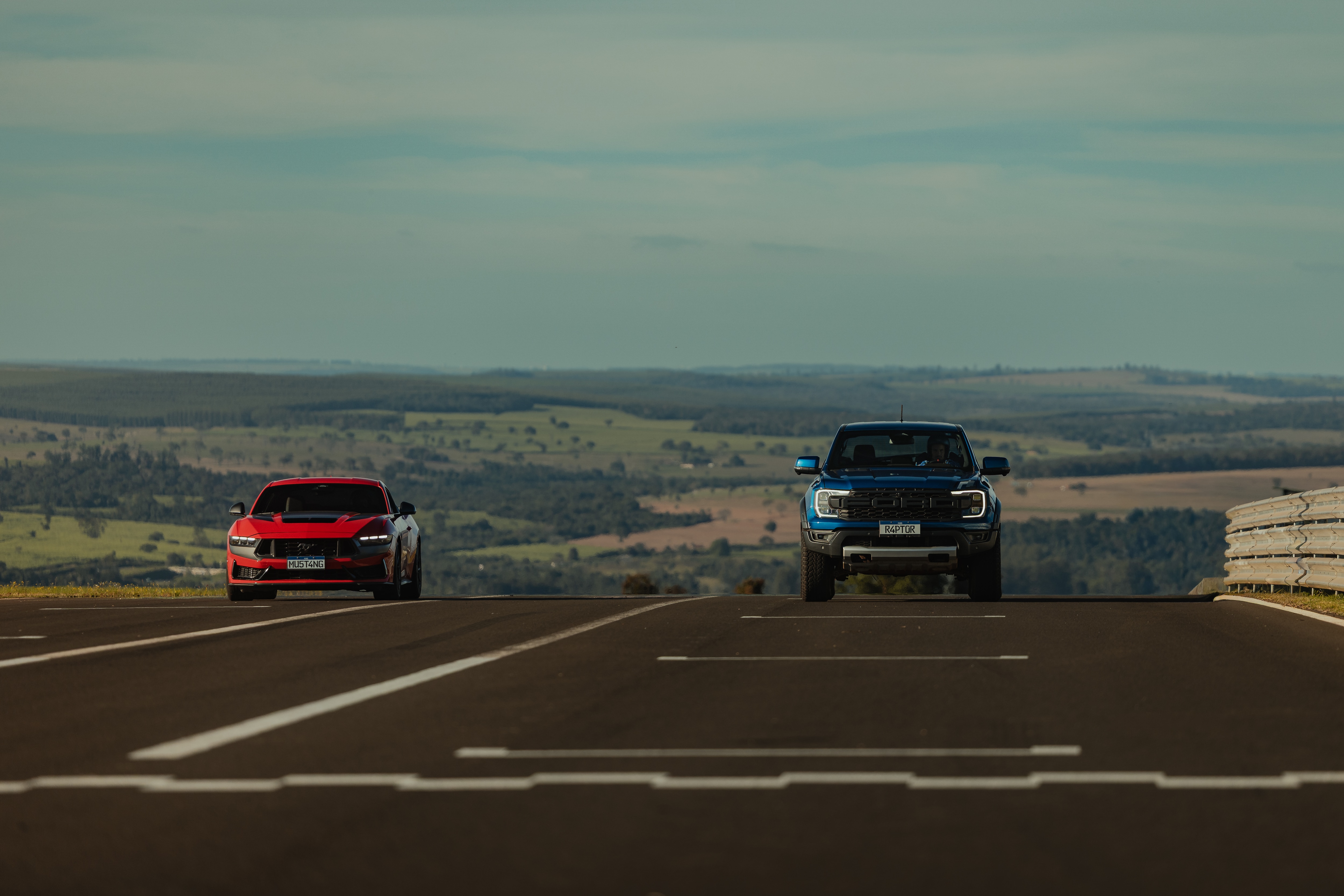 Ford Mustang Dark Horse vermelho na pista com uma Ford Ranger Raptor azul